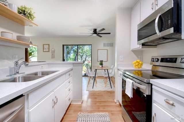52 Margarita Ter, Novato, CA 94947 - kitchen with stainless steel appliances, open shelves, a sink, light wood-style floors, and white cabinetry