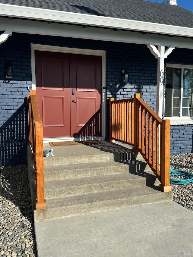 69 Eastside Cir, Petaluma, CA 94954 - view of exterior entry featuring brick siding, a shingled roof, and covered porch