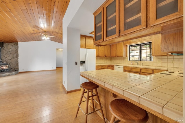 19828 Greenview Dr, Twain Harte, CA 95383 - kitchen featuring open floor plan, a wood stove, decorative backsplash, vaulted ceiling, and white appliances