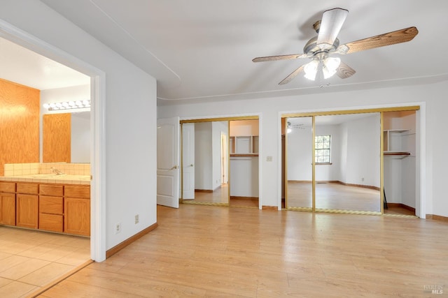19828 Greenview Dr, Twain Harte, CA 95383 - unfurnished bedroom with multiple closets, light wood-style flooring, baseboards, a sink, and connected bathroom