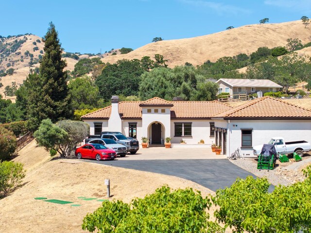 1745 Durbin Ln, Fairfield, CA 94534 - mediterranean / spanish-style house with stucco siding, a mountain view, a chimney, and a tiled roof