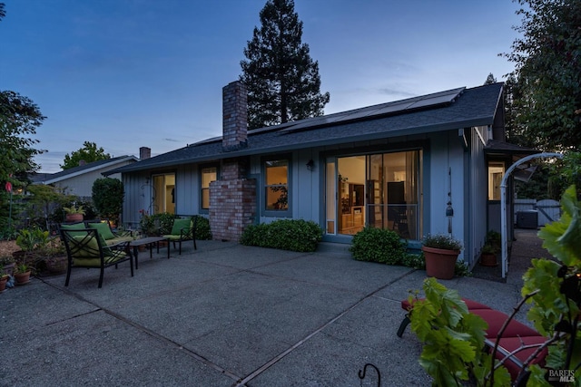 2010 Caulfield Ln, Petaluma, CA 94954 - back of house featuring a patio, a chimney, roof mounted solar panels, and roof with shingles