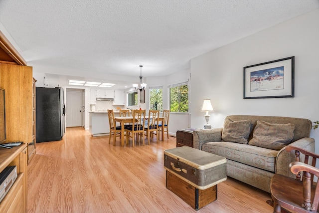 2010 Caulfield Ln, Petaluma, CA 94954 - living area with a chandelier, light wood-style flooring, a textured ceiling, and baseboards