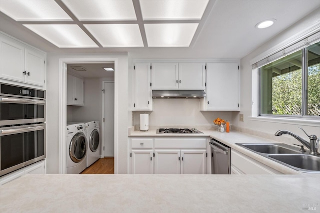 2010 Caulfield Ln, Petaluma, CA 94954 - kitchen featuring washer and dryer, a sink, stainless steel appliances, under cabinet range hood, and white cabinets