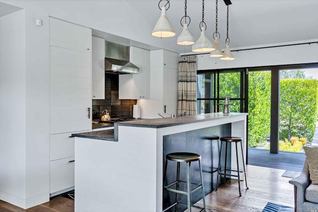 1005 Valley View St, Saint Helena, CA 94574 - kitchen with dark countertops, white cabinets, dark wood finished floors, backsplash, and wall chimney exhaust hood