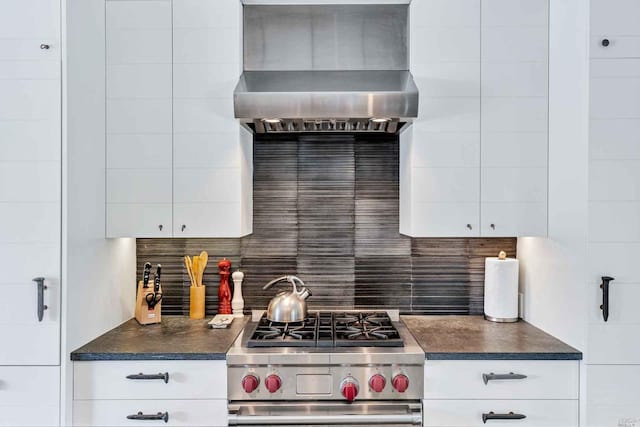 1005 Valley View St, Saint Helena, CA 94574 - kitchen featuring high end stainless steel range oven, wall chimney range hood, dark countertops, tasteful backsplash, and white cabinets