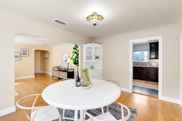 740 Valle Vista Ave, Vallejo, CA 94590 - dining space with arched walkways, light wood-style floors, and baseboards