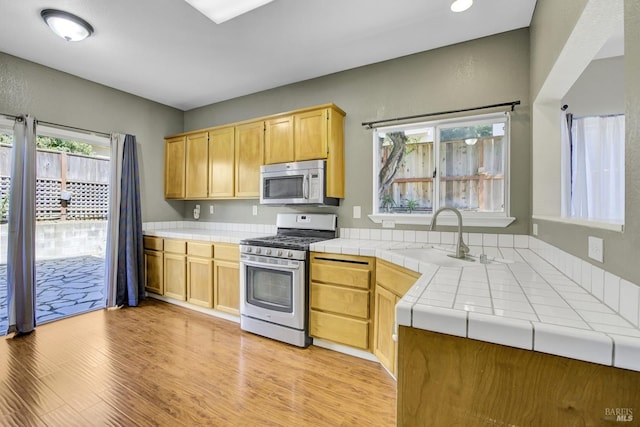 115 Barington Dr, Vallejo, CA 94591 - kitchen with appliances with stainless steel finishes, tile countertops, a sink, and light wood-type flooring