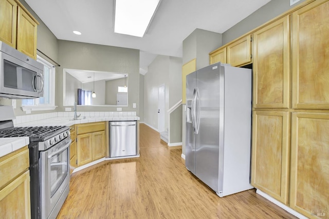 115 Barington Dr, Vallejo, CA 94591 - kitchen with stainless steel appliances, tile counters, light brown cabinetry, light wood-style flooring, and a peninsula