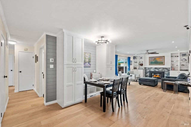 3524 Cascade St, Napa, CA 94558 - dining space featuring light wood-style flooring, crown molding, a tiled fireplace, a ceiling fan, and baseboards