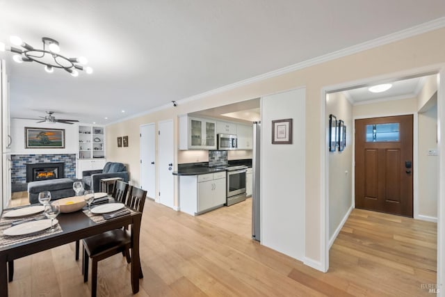 3524 Cascade St, Napa, CA 94558 - dining room with a fireplace, light wood finished floors, a ceiling fan, baseboards, and ornamental molding
