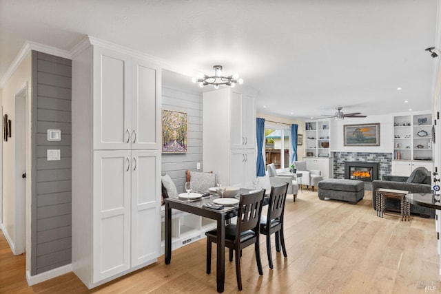 3524 Cascade St, Napa, CA 94558 - dining room with light wood-style flooring, ornamental molding, a ceiling fan, a tiled fireplace, and a chandelier