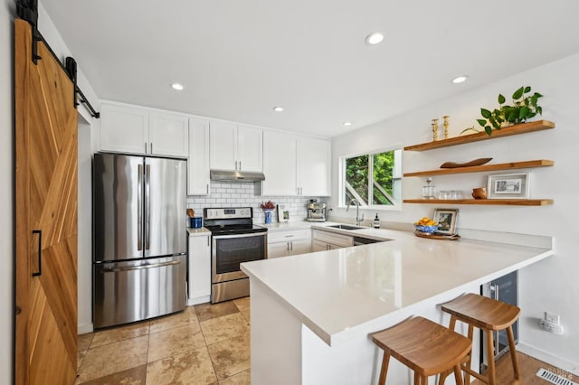 110 Morning Sun Ave, Mill Valley, CA 94941 - kitchen featuring stainless steel appliances, under cabinet range hood, a barn door, a sink, and a peninsula