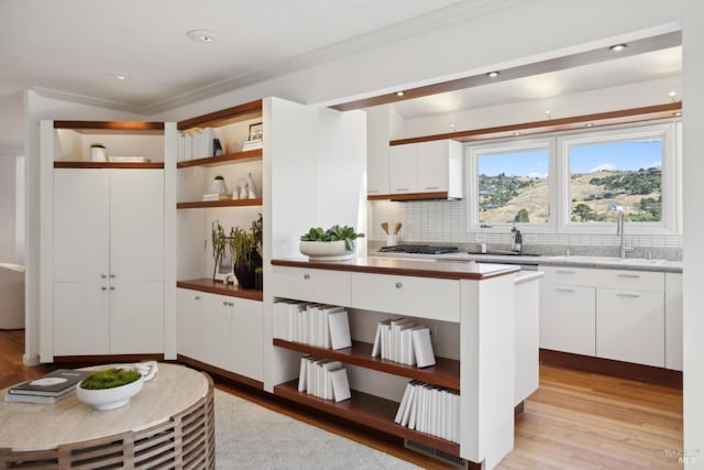 84 Eastview Ave, Tiburon, CA 94920 - kitchen with light wood-style floors, backsplash, open shelves, white cabinetry, and ornamental molding