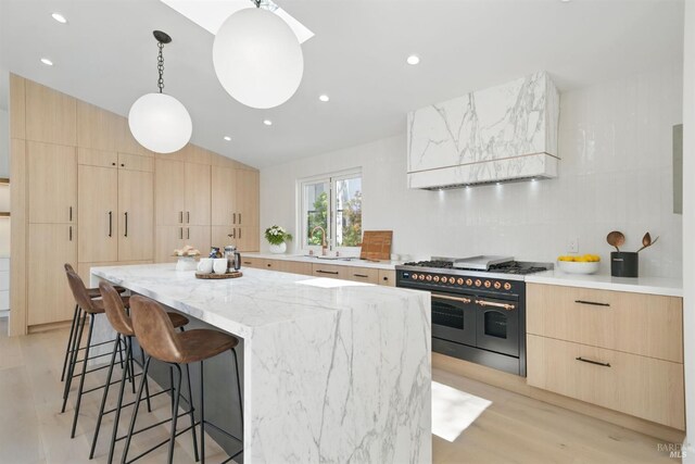 21 Sheridan Ct, Mill Valley, CA 94941 - kitchen featuring range with two ovens, light brown cabinets, modern cabinets, a kitchen breakfast bar, and vaulted ceiling
