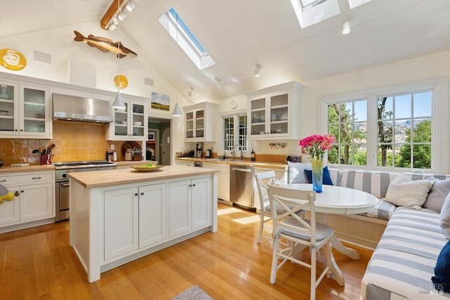3227 State Highway 128, Calistoga, CA 94515 - kitchen with a skylight, wall chimney range hood, appliances with stainless steel finishes, a sink, and butcher block counters