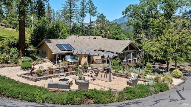 3227 State Highway 128, Calistoga, CA 94515 - rear view of house featuring a fire pit, a patio area, roof mounted solar panels, a mountain view, and a pergola