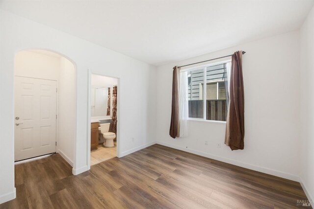 1142 Kellogg St, Suisun City, CA 94585 - spare room with wood finished floors, arched walkways, and baseboards