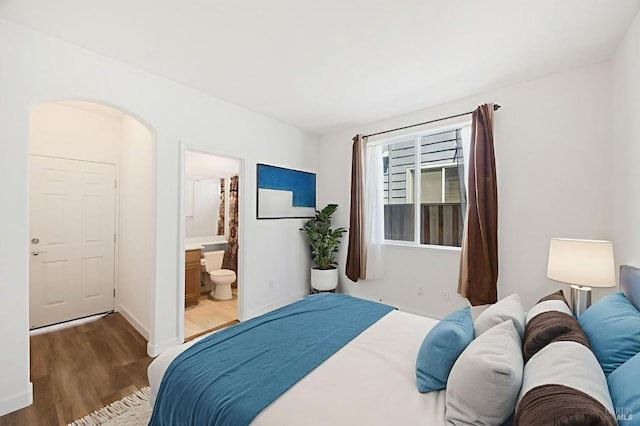 1142 Kellogg St, Suisun City, CA 94585 - bedroom featuring wood finished floors, arched walkways, baseboards, and ensuite bathroom