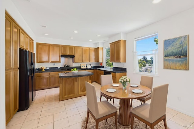 1142 Kellogg St, Suisun City, CA 94585 - kitchen featuring black fridge with ice dispenser, a center island, light tile patterned floors, dark countertops, and under cabinet range hood