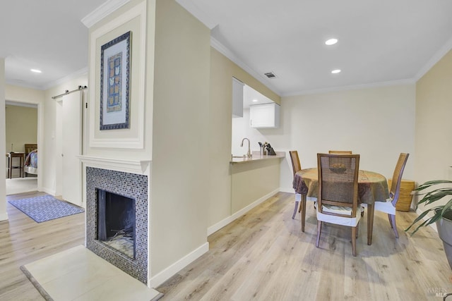 131 Roundtree Blvd, San Rafael, CA 94903 - dining area with light wood-style flooring, ornamental molding, recessed lighting, baseboards, and a tile fireplace