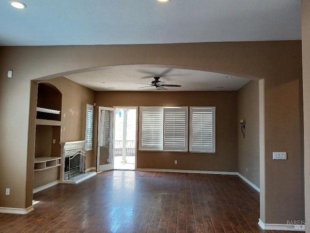 2743 Overlook Dr, Vallejo, CA 94591 - unfurnished living room with a ceiling fan, arched walkways, hardwood / wood-style flooring, baseboards, and a fireplace with raised hearth