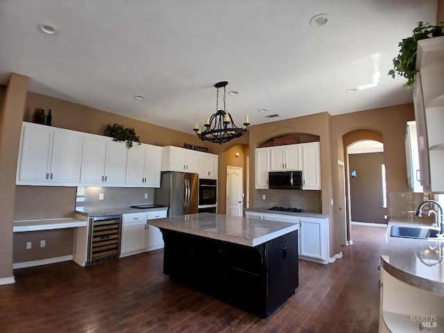 2743 Overlook Dr, Vallejo, CA 94591 - kitchen featuring beverage cooler, black appliances, a sink, a kitchen island, and tasteful backsplash