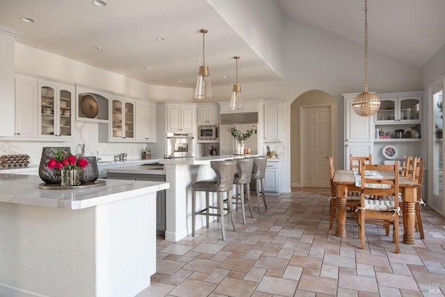 4588 Bennett Valley Rd, Santa Rosa, CA 95404 - kitchen featuring built in appliances, a kitchen breakfast bar, light countertops, a kitchen island, and glass insert cabinets