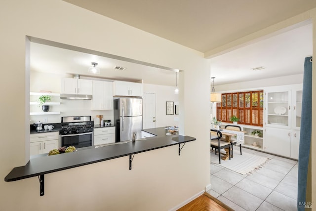 238 Ebbetts Pass Rd, Vallejo, CA 94589 - kitchen featuring appliances with stainless steel finishes, under cabinet range hood, dark countertops, and a peninsula