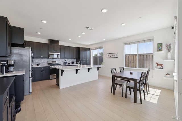 2413 Village Square Blvd, Fairfield, CA 94533 - kitchen with appliances with stainless steel finishes, a kitchen breakfast bar, light countertops, backsplash, and a sink