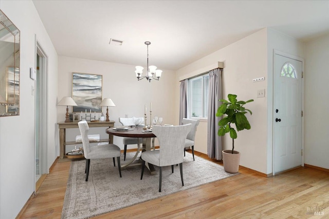 dining room featuring plenty of natural light, a chandelier, and light wood-type flooring