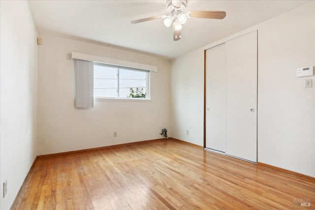 unfurnished bedroom featuring light wood-style flooring, a closet, and a ceiling fan