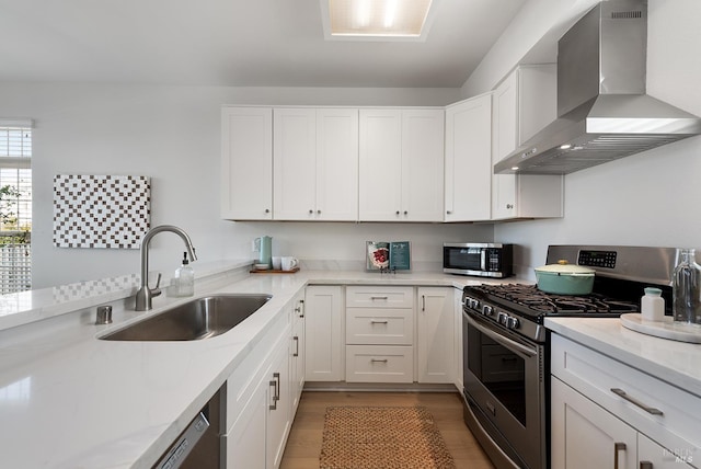 306 Commodore Dr, Richmond, CA 94804 - kitchen featuring stainless steel appliances, wall chimney exhaust hood, light wood-style floors, and white cabinetry