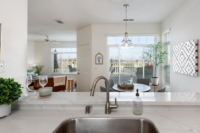306 Commodore Dr, Richmond, CA 94804 - kitchen with light stone countertops, ceiling fan, and hanging light fixtures