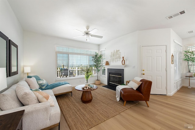 306 Commodore Dr, Richmond, CA 94804 - living area with light wood-type flooring, ceiling fan, and a fireplace with flush hearth