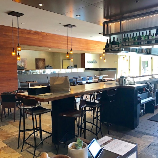 1314 Mckinstry St Unit 2008, Napa, CA 94559 - bar area featuring stone tile flooring, recessed lighting, wooden walls, and decorative light fixtures