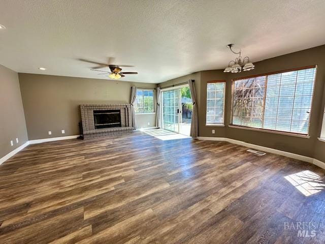 1540 Mccarthy Ct, Dixon, CA 95620 - unfurnished living room with a ceiling fan, a chandelier, a brick fireplace, dark wood-type flooring, and recessed lighting