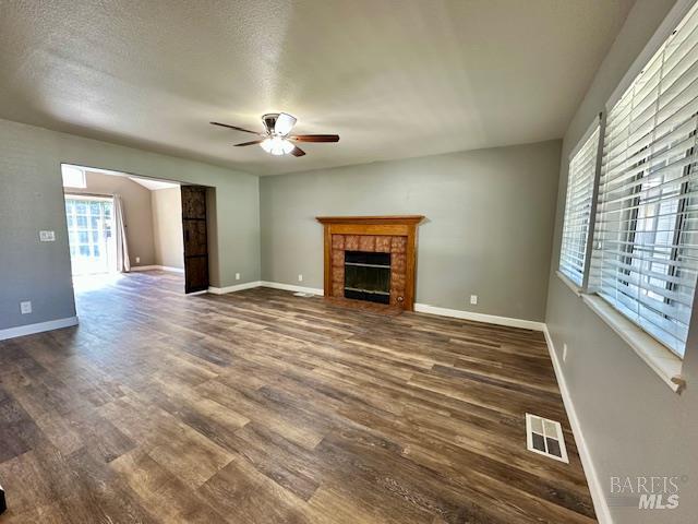 1540 Mccarthy Ct, Dixon, CA 95620 - unfurnished living room with a ceiling fan, dark wood-style floors, and a tile fireplace