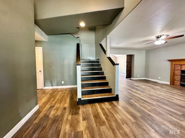 1540 Mccarthy Ct, Dixon, CA 95620 - stairway featuring a ceiling fan, wood finished floors, and a fireplace