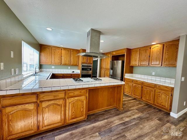 1540 Mccarthy Ct, Dixon, CA 95620 - kitchen featuring stainless steel appliances, island range hood, dark wood-style floors, tile counters, and recessed lighting