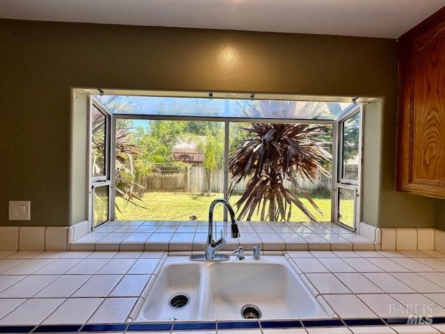 1540 Mccarthy Ct, Dixon, CA 95620 - kitchen with tile countertops, plenty of natural light, and brown cabinetry