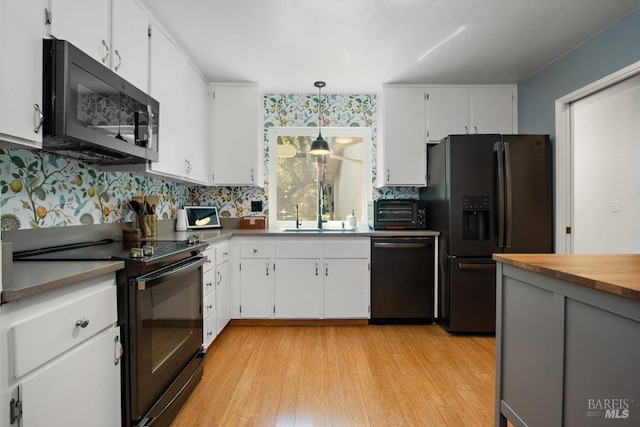 1800 London Dr, Benicia, CA 94510 - kitchen featuring black appliances, a sink, light wood finished floors, and white cabinets