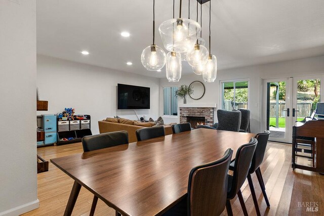 1800 London Dr, Benicia, CA 94510 - dining area featuring light wood-style floors, a fireplace, recessed lighting, and french doors