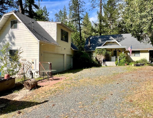 9826 Meadow Dr, Cobb, CA 95426 - view of front of home with gravel driveway, a garage, and a shingled roof
