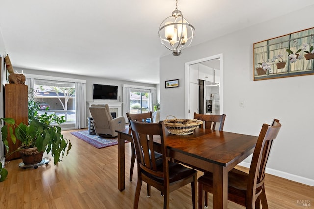 6518 Meadowgreen Pl, Santa Rosa, CA 95409 - dining room featuring healthy amount of natural light, light wood finished floors, a chandelier, and a fireplace