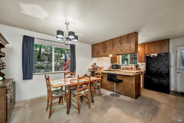 16545 Mountain View Dr, Cobb, CA 95426 - dining area featuring a chandelier, concrete flooring, and a textured ceiling