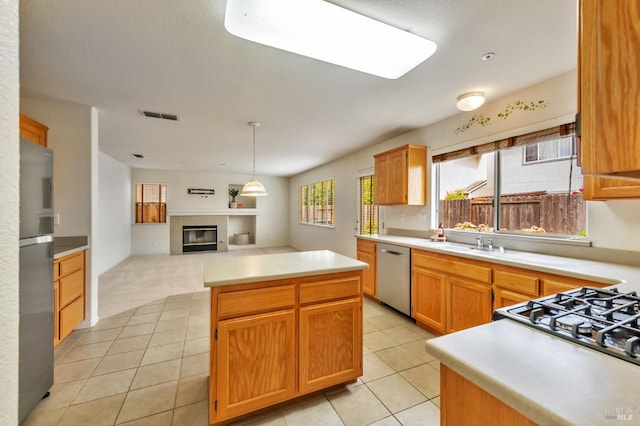 8046 Mason Dr, Rohnert Park, CA 94928 - kitchen featuring appliances with stainless steel finishes, a center island, open floor plan, a tile fireplace, and light countertops