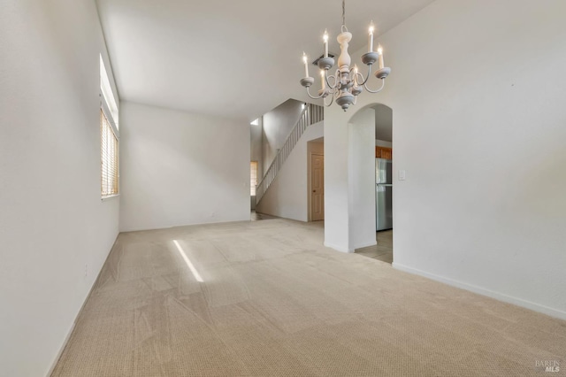 8046 Mason Dr, Rohnert Park, CA 94928 - spare room with arched walkways, light colored carpet, a chandelier, stairs, and a high ceiling