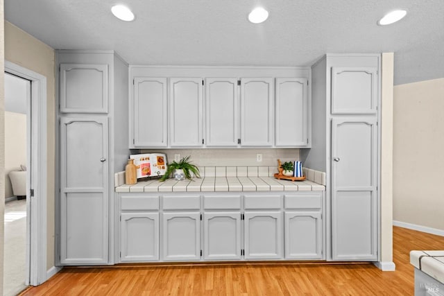 431 Inverness Way, Vacaville, CA 95687 - kitchen featuring light wood-style floors, white cabinetry, tile counters, a textured ceiling, and recessed lighting
