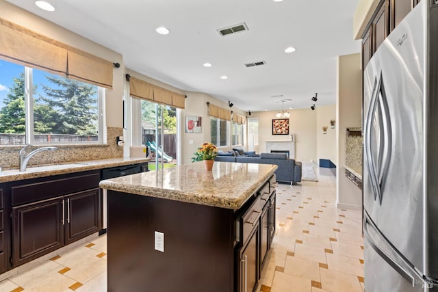 473 Mccall Dr, Benicia, CA 94510 - kitchen with freestanding refrigerator, recessed lighting, black dishwasher, light stone countertops, and a sink
